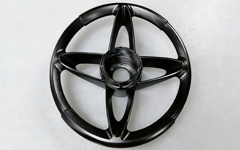Black anodized custom billet steering wheel with 4-spoke design and 3D contoured shape.