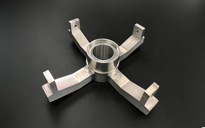 Industrial Automation CNC Machining Part featuring a structural aluminum cross-link design with a central bore and four perpendicular mounting arms.
