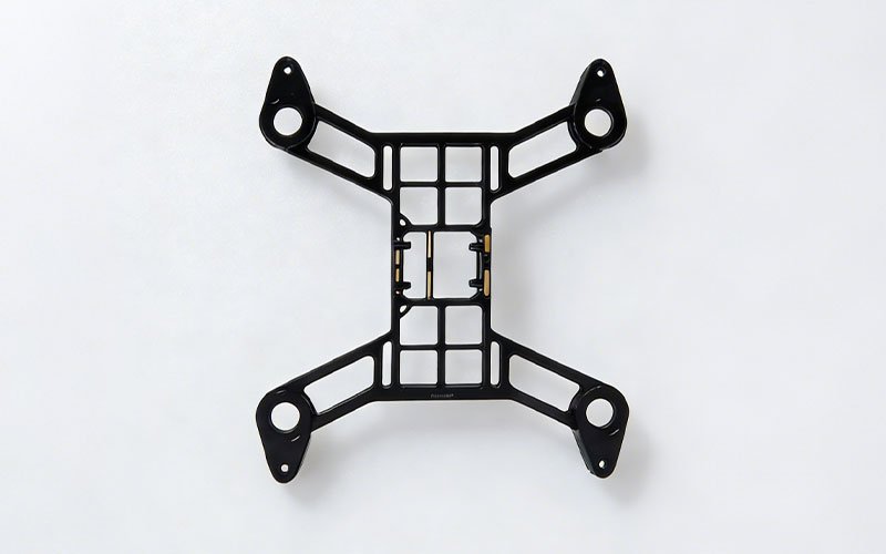 Top view of CNC machined aluminum 7075 drone frame with black anodized finish. Features skeletonized grid design for lightweight performance.