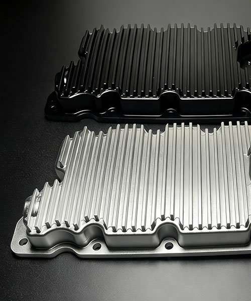 CNC machined aluminum heat sinks with integrated cooling fins. Top unit features black anodizing; bottom unit shows natural bead blasted finish.
