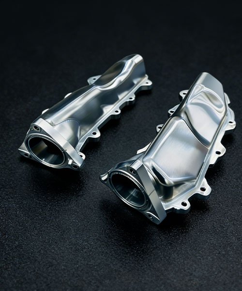 Custom 5-axis CNC machined billet aluminum intake runners featuring optimized airflow geometry and smooth internal bores for high-performance automotive engines.