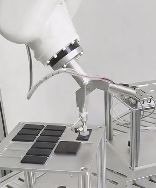 6-axis industrial robot performing pick and place operation using a custom CNC machined aluminum vacuum gripper end-effector.