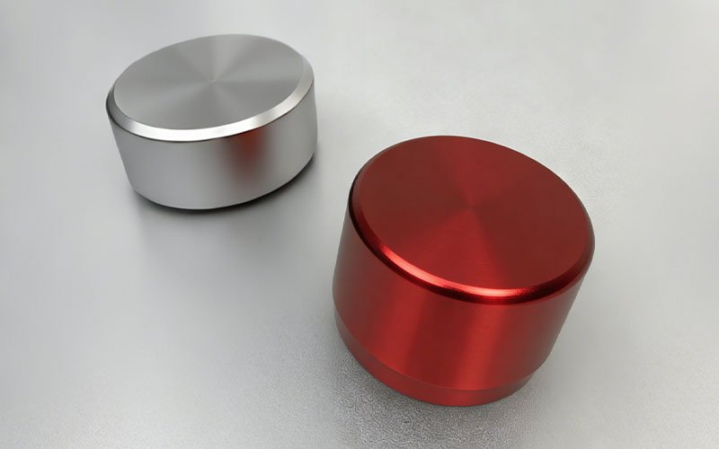 Precision CNC machined aluminum knobs with radial brushed CD pattern in red and silver finishes.