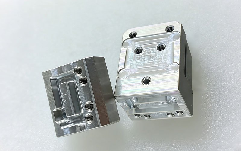 As-Machined Surface Finish on CNC Aluminum Parts Two precision CNC machined aluminum parts showing the as-machined surface finish, with visible tool paths and milled features.
