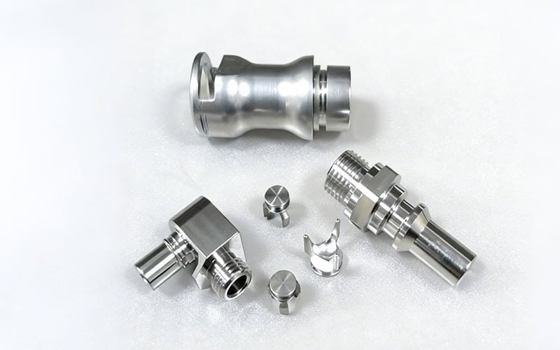 Custom CNC machined 316L stainless steel liquid cooling connectors, featuring turned fittings and internal valve components.