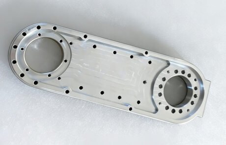 CNC machined aluminum transmission housing for automation, featuring two large bearing bores and multiple mounting holes.