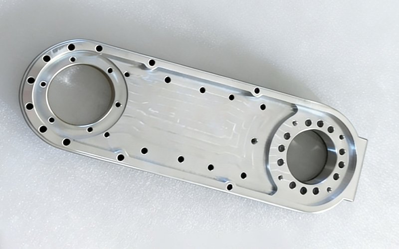 CNC machined aluminum transmission housing for automation, featuring two large bearing bores and multiple mounting holes.