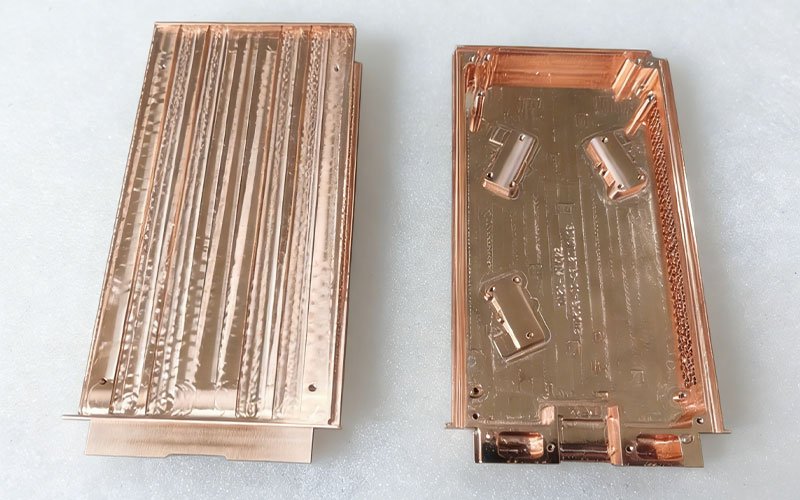 CNC machined C11000 copper parts for vapor chambers, showing internal cooling channels and support structures.