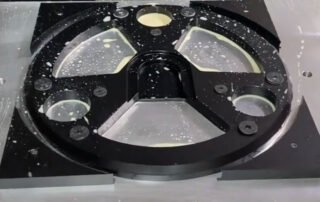 CNC machining setup for a complex black POM part using custom stress-free fixturing to prevent warping.