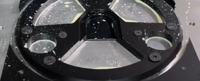 CNC machining setup for a complex black POM part using custom stress-free fixturing to prevent warping.