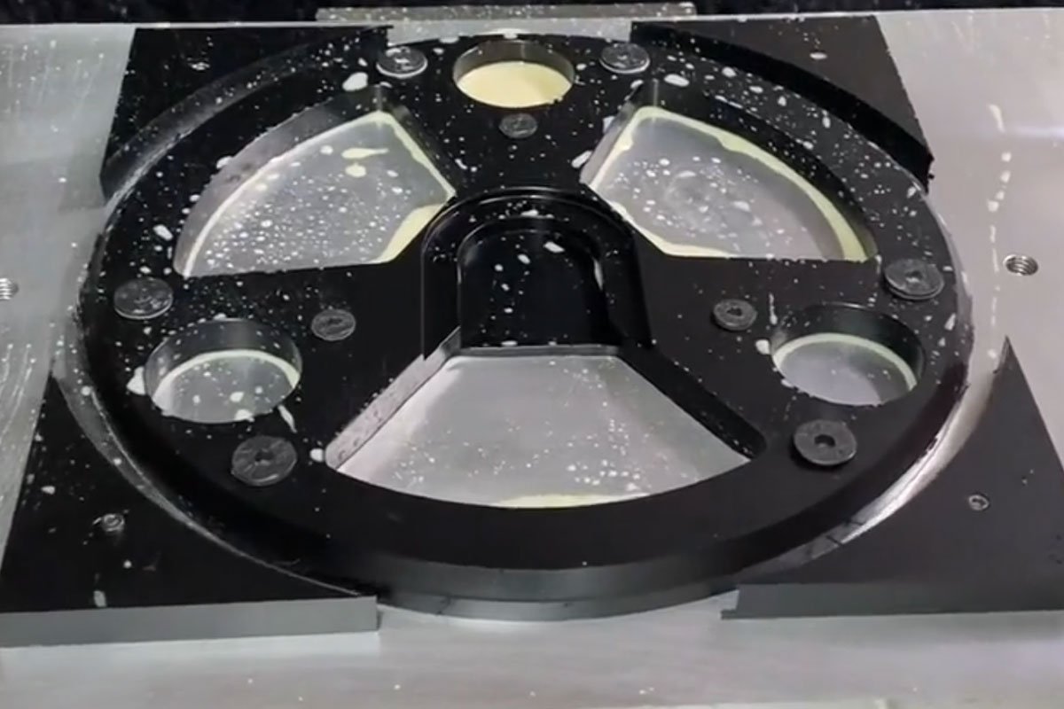 CNC machining setup for a complex black POM part using custom stress-free fixturing to prevent warping.