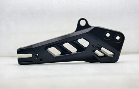 Custom CNC machined aluminum bicycle swingarm with hollow design and black anodized finish for aftermarket upgrades.