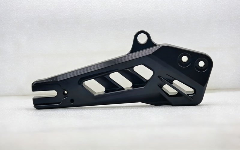 Custom CNC machined aluminum bicycle swingarm with hollow design and black anodized finish for aftermarket upgrades.