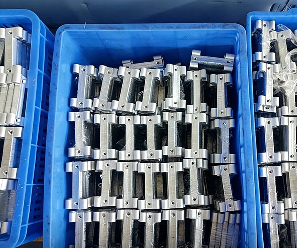 Low-Volume Manufacturing Custom Aluminum Brackets Low-volume manufacturing of CNC aluminum parts packed in crates for shipping.