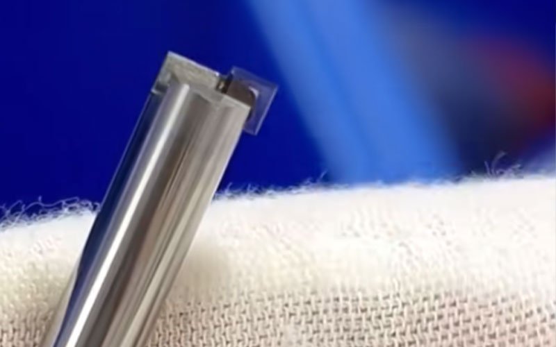 Close-up of the single-crystal diamond tip used for finishing passes. The atomic-level sharpness allows for chip removal without surface tearing.