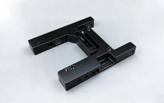 High-precision CNC machined black anodized aluminum part, representing functional prototyping quality in a comparison guide against 3D printing and vacuum casting.