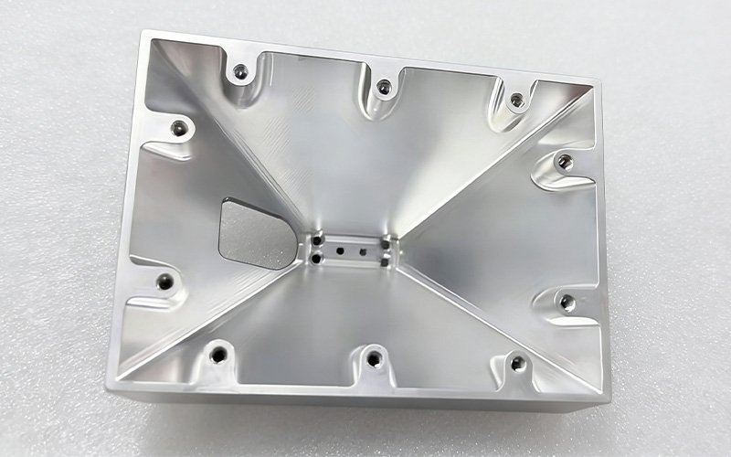 Internal view of a CNC milled aluminum telecom enclosure featuring deep cavity and tapped mounting holes.
