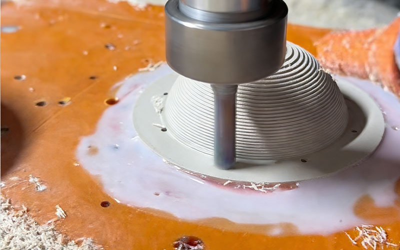 CNC milling of a thin-walled PEEK GF30 part secured to a Bakelite fixture plate using two-part epoxy to prevent clamping deformation.