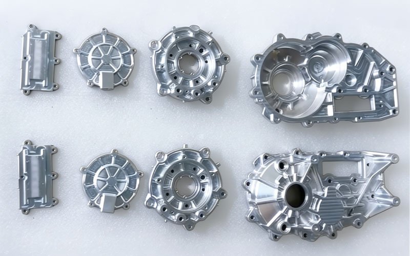 A set of CNC machined aluminum gearbox components.