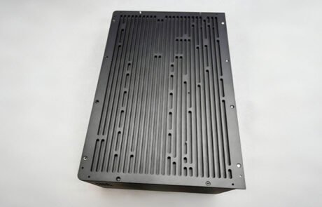 Top view of a custom CNC machined aluminum 6061 IPC chassis cover featuring a black matte anodized finish and high-density longitudinal ventilation slots.
