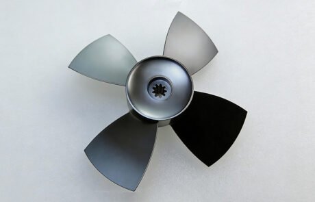 Finished CNC machined aluminum fan with 4 blades and spline hub, black anodized.