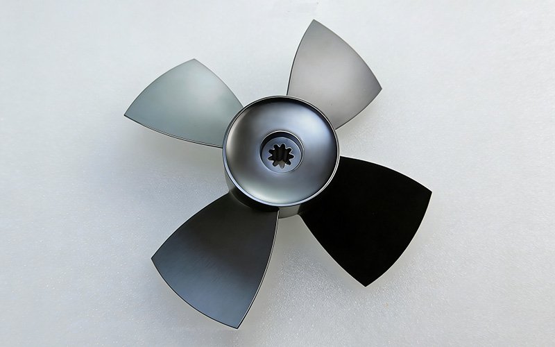 Finished CNC machined aluminum fan with 4 blades and spline hub, black anodized.