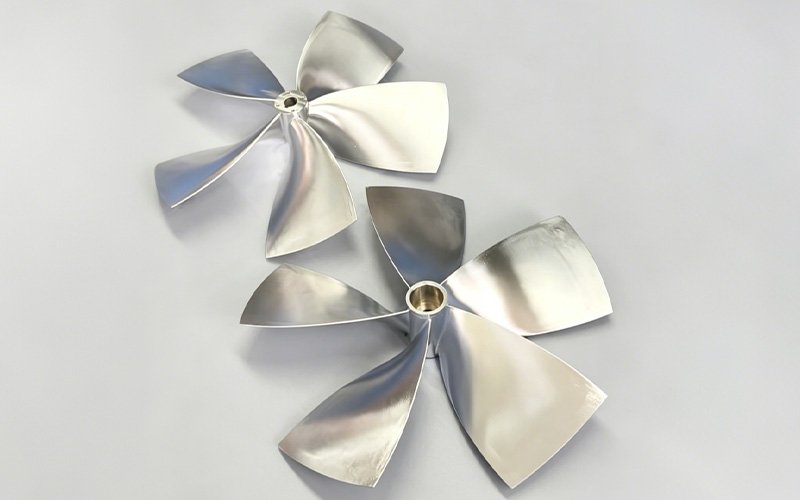 Two polished 316L stainless steel custom marine propellers manufactured by 5-axis CNC machining.