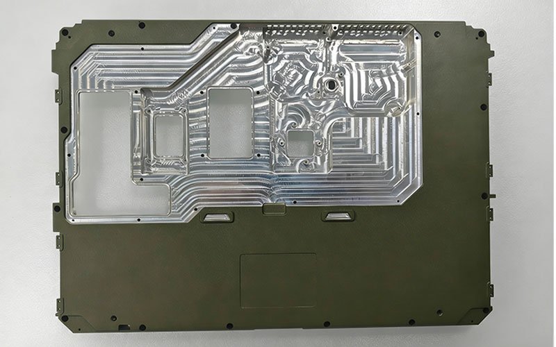 Internal view of a CNC machined aluminum rugged laptop chassis showing complex milling tool paths and component compartments.