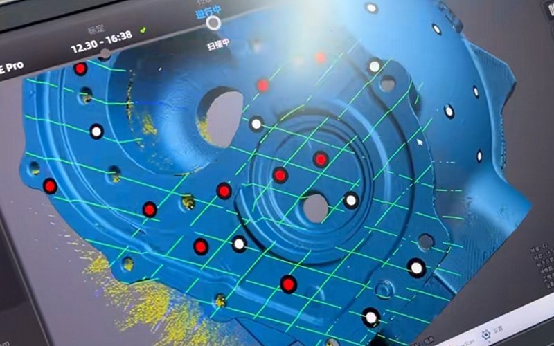3D scan point cloud mesh of a gearbox housing face displayed in scanning software, with red and white reference markers visible