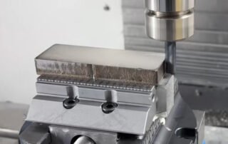 316L stainless steel block clamped in a serrated high-precision vice during CNC machining