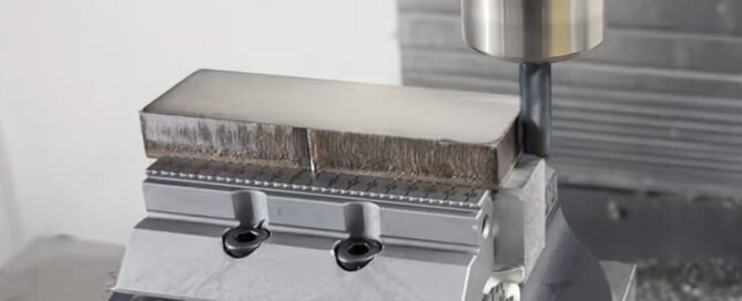 316L stainless steel block clamped in a serrated high-precision vice during CNC machining