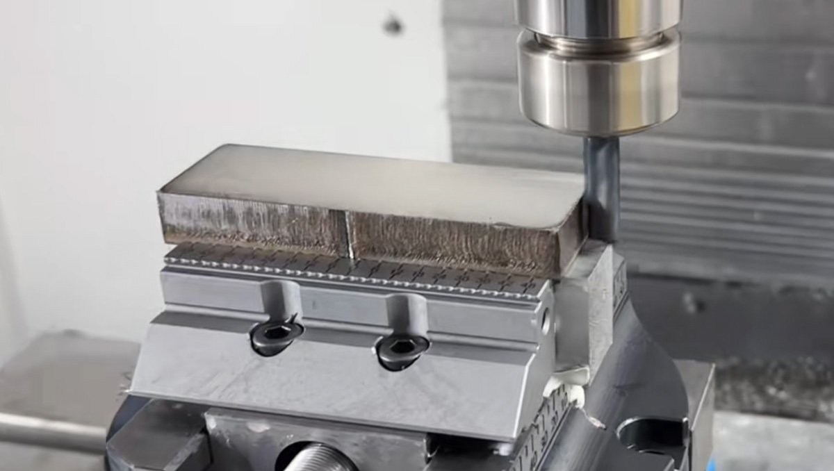 316L stainless steel block clamped in a serrated high-precision vice during CNC machining