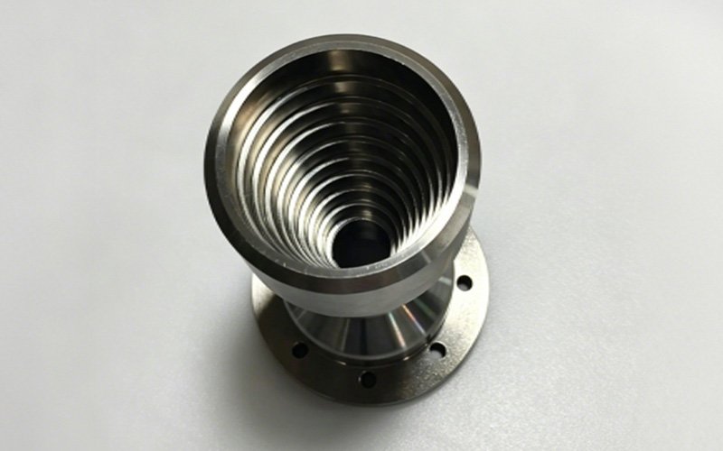 Custom Stainless Steel Flanged Conical Threaded Tube – Three-Quarter View Three-quarter view of custom CNC turned stainless steel flanged conical threaded tube showing exterior taper and inner thread