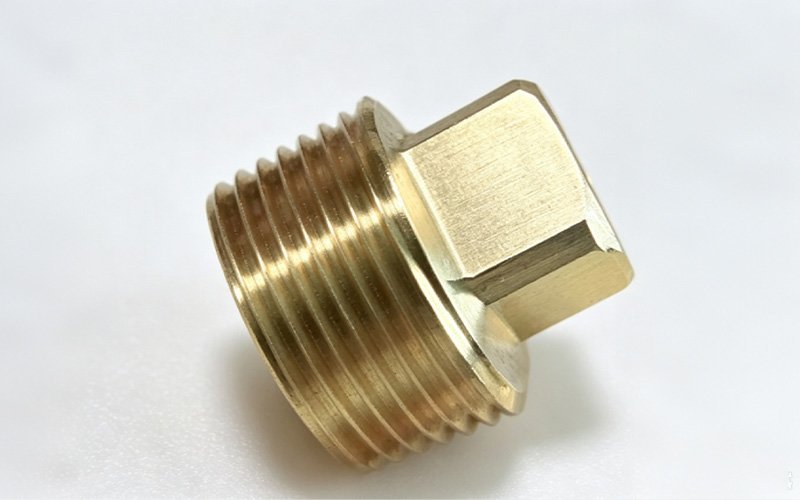 Custom CNC machined non-standard brass plug with an external thread and square drive head