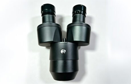Custom CNC machined aluminum microscope housing for a binocular head, black anodized with eyepiece tubes and knurled rings