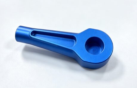 Custom tool handle CNC machined from aluminum to a customer's drawing, with an ergonomic groove and blue anodized finish