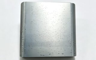 Machined 7075 aluminum part with black spots and mottling after clear (natural) anodizing