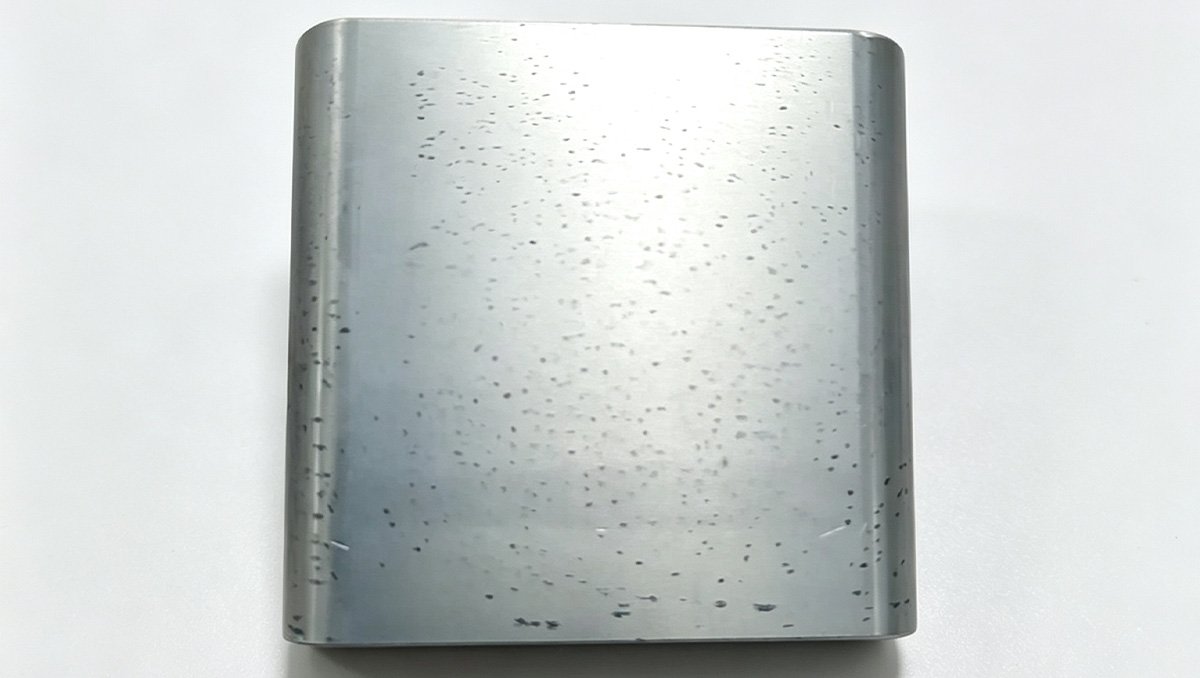 Machined 7075 aluminum part with black spots and mottling after clear (natural) anodizing