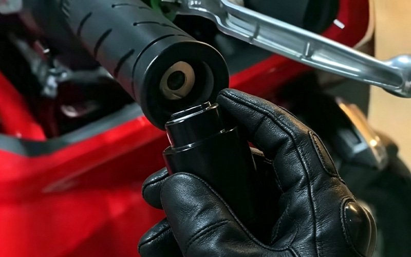 Removing the stock black bar end weight from a Honda NX500 handlebar by hand