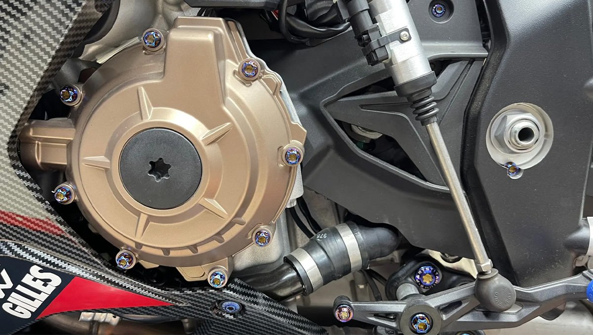 Rainbow anodized titanium bolts on a motorcycle engine cover