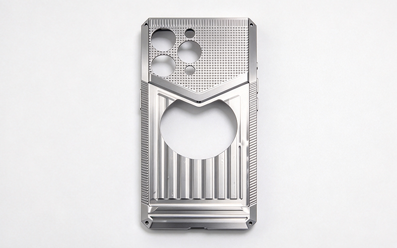 Custom CNC machined titanium phone case with camera cutouts and a textured grip panel